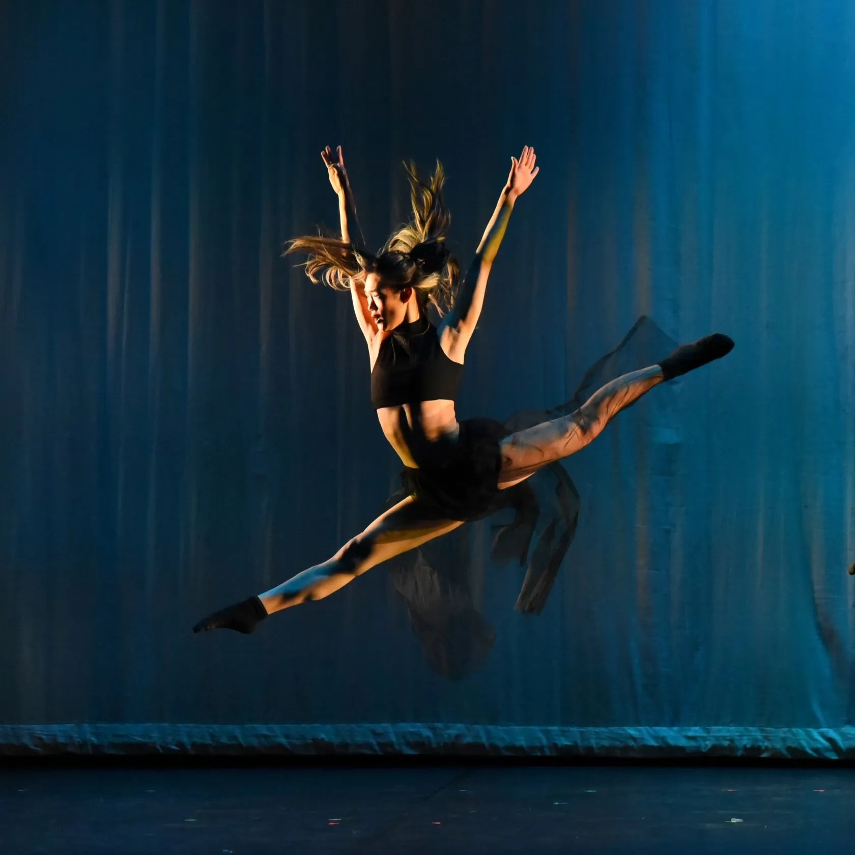 Ceci Sun - Dancer in Mid-Air Against a Blue Curtain